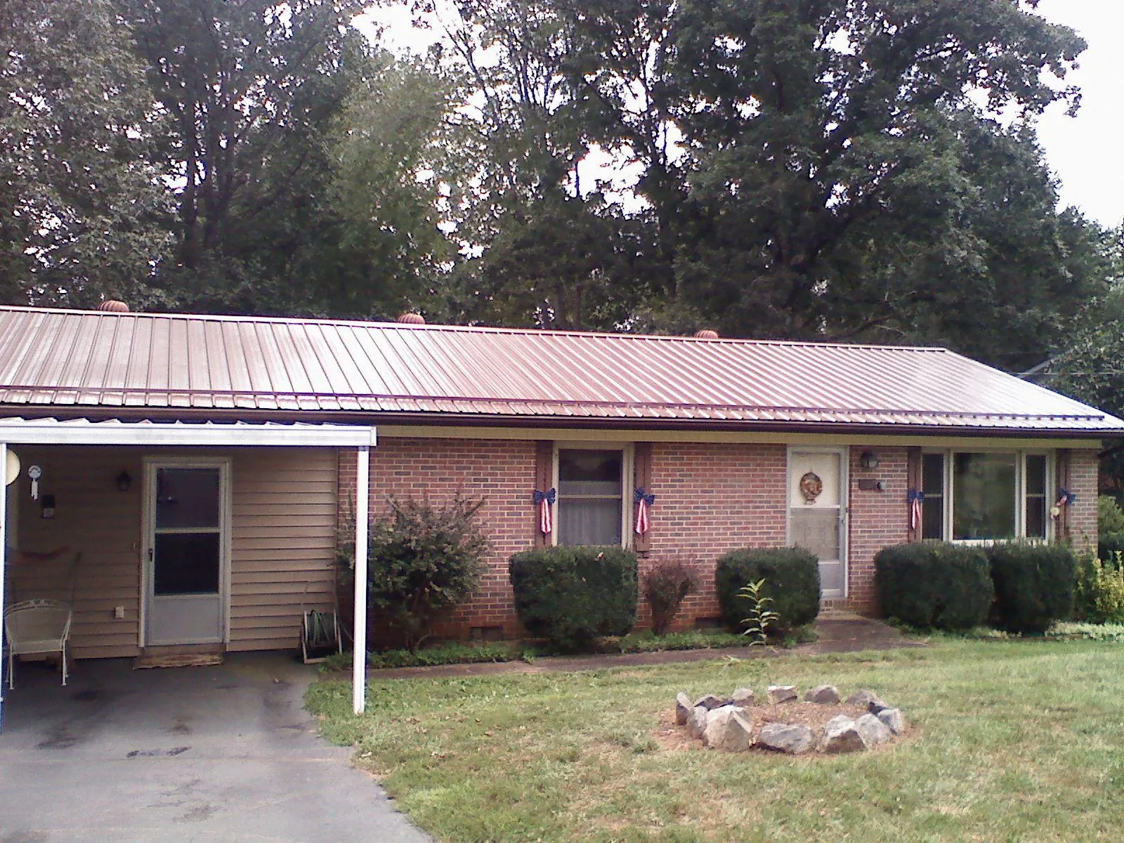 Bronze metal roof and carport on a brick ranch home — Roof Repair work by our crew in Carrollton
