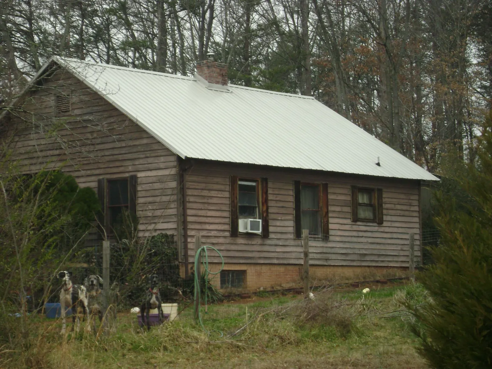White metal roof on an old wood sided farmhouse, from a Asphalt Shingle Roof Repair job in Carrollton
